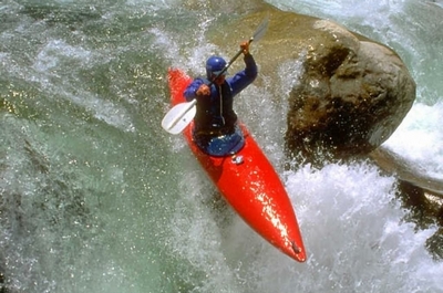 Foto di un canoista che scende lungo un torrente impetuoso